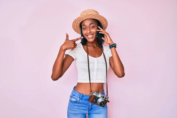 Joven Mujer Afroamericana Sosteniendo Cámara Vintage Hablando Teléfono Inteligente Sonriendo —  Fotos de Stock