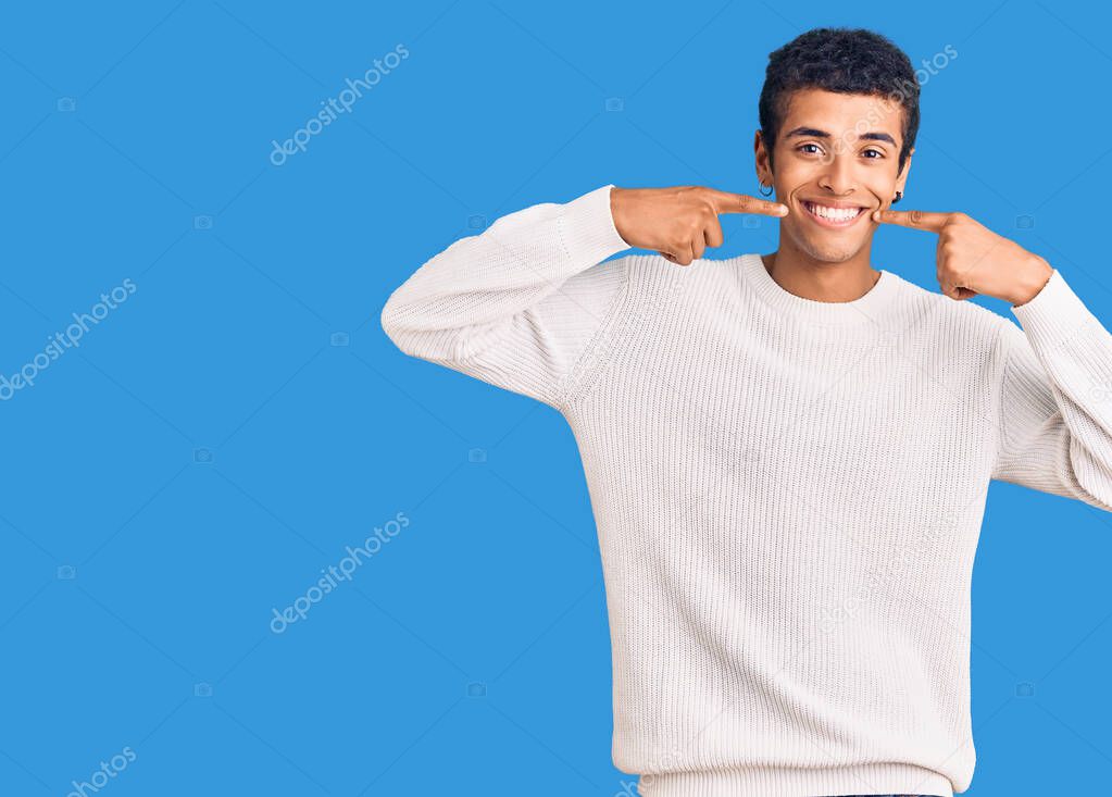 Young african amercian man wearing casual clothes smiling cheerful showing and pointing with fingers teeth and mouth. dental health concept. 
