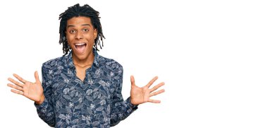 80 'lerin tişörtlü genç Afro-Amerikan erkeği zaferi mutlu bir gülümsemeyle ve kazanan yüz ifadesiyle kutluyor. 