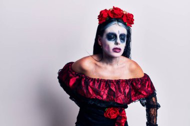 Meksika 'nın ölü makyajından giyinen genç bir kadın sırt ağrısı çekiyor, elleriyle dokunuyor, kas ağrısı çekiyor. 