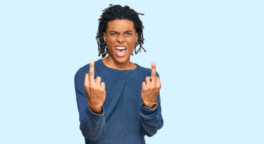 Young african american man wearing casual winter sweater showing middle finger doing fuck you bad expression, provocation and rude attitude. screaming excited 