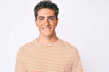 Yüzünde mutlu ve havalı bir gülümseme olan sıradan kıyafetler giyen genç yakışıklı bir adam. şanslı kişi. 