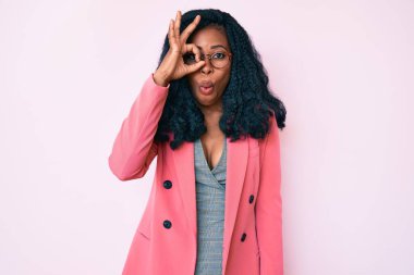 İş ceketi ve gözlük takan güzel Afrikalı kadın şaşırmış yüz ifadesiyle şaşırmış, parmaklarından bakan gözler. İnançsız ifade. 