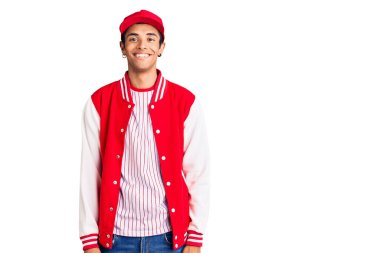 Beyzbol forması giyen, yüzünde mutlu ve havalı bir gülümseme olan genç bir Afrikalı Amerikalı. şanslı kişi. 