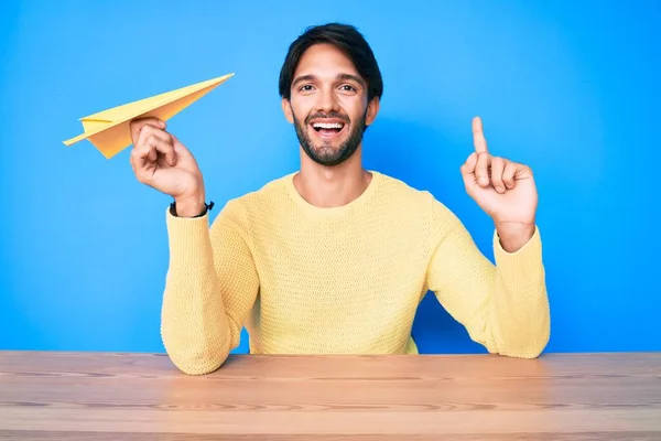 Hombre Hispano Guapo Sosteniendo Avión Papel Sorprendido Con Una Idea —  Fotos de Stock