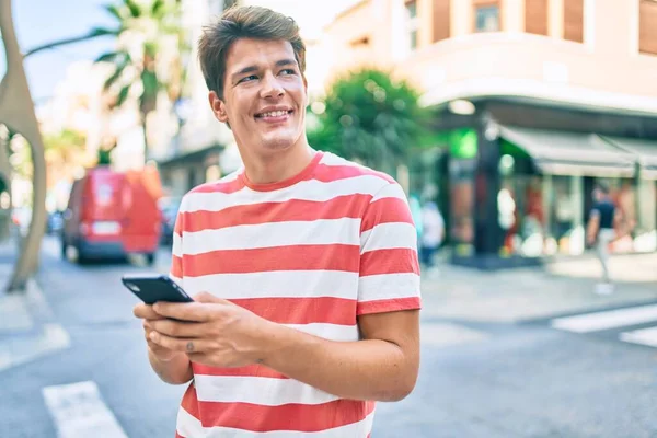 Mladý Kavkazský Muž Usměvavý Šťastný Pomocí Smartphonu Městě — Stock fotografie