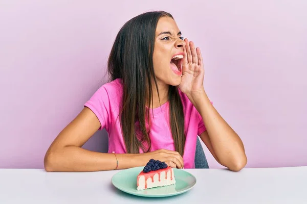 Young Hispanic Woman Eating Cheesecake Sitting Table Shouting Screaming Loud — Stock Photo, Image