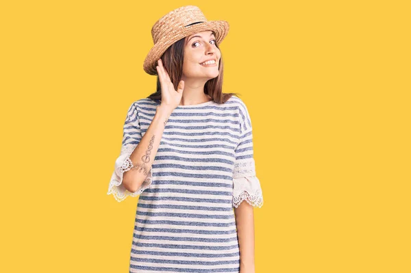 噂やゴシップに耳を傾ける耳の上に手で笑みを浮かべて夏の帽子をかぶって美しい白人女性 聴覚障害の概念 — ストック写真