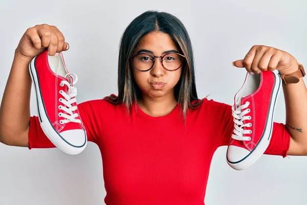 Joven Chica Latina Sosteniendo Zapatos Casuales Rojos Hinchando Mejillas Con —  Fotos de Stock