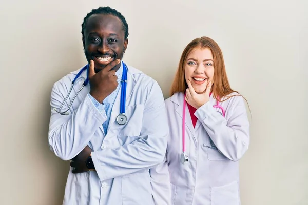 Joven Pareja Interracial Vistiendo Uniforme Médico Estetoscopio Mirando Con Confianza —  Fotos de Stock