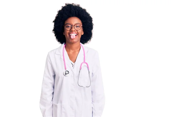 Fiatal Afro Amerikai Orvosi Kabátot Sztetoszkópot Visel Vicces Arckifejezéssel Kidugja — Stock Fotó