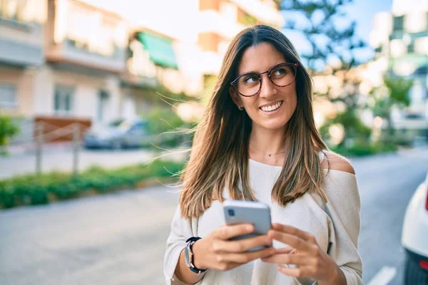 Νεαρή Καυκάσια Γυναίκα Χαμογελά Ευτυχισμένη Χρησιμοποιώντας Smartphone Στην Πόλη — Φωτογραφία Αρχείου