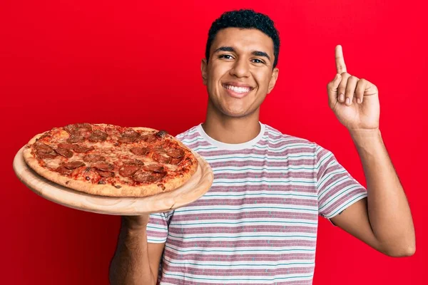 Jovem Árabe Segurando Pizza Italiana Surpreso Com Uma Ideia Pergunta — Fotografia de Stock