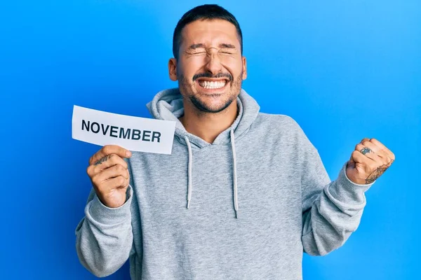 Handsome Man Tattoos Holding November Word Paper Screaming Proud Celebrating — Stock Photo, Image