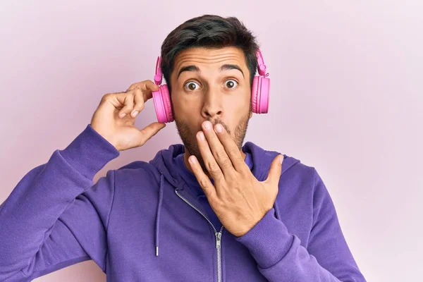 Young Handsome Man Listening Music Using Headphones Covering Mouth Hand — Stock Photo, Image