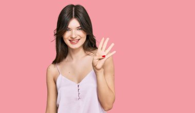 Genç, güzel, beyaz, günlük kıyafetler giyen, dört numaralı parmaklarıyla işaret eden, kendinden emin ve mutlu bir şekilde gülümseyen kız.. 