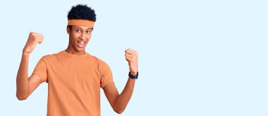 Genç Afrikalı Amerikalı erkek spor giyer gururla bağırır, zaferi kutlar ve kollarını kaldırarak heyecanlanır. 