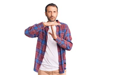 Gündelik kıyafetler giyen genç yakışıklı bir adam. Elleriyle jest yapıyor, hayal kırıklığına uğramış ve ciddi bir yüz ifadesi takınıyor. 