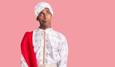 Geleneksel Sherwani elbisesi giyen Afrikalı yakışıklı bir adam dudaklarıyla balık suratı yapıyor, çılgınca ve komik bir jest. Komik ifade. 