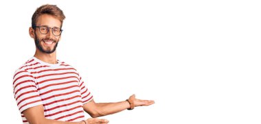 Sakallı, sıradan kıyafetler ve gözlük takan yakışıklı sarışın adam gülümseyerek içeri girmeye davet ediyor. 