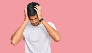 Genç, yakışıklı bir adam günlük beyaz tişört giyiyor. Baş ağrısı çekiyor. Acı ve migren yüzünden çaresiz ve stresli. Eller başının üstünde.. 