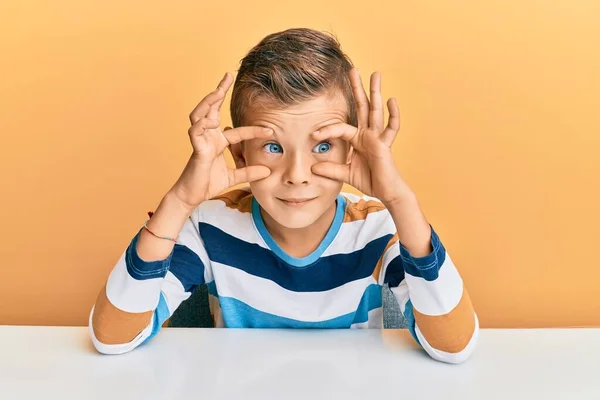 Kafkasyalı Sevimli Çocuk Günlük Giysiler Içinde Masaya Oturmuş Parmaklarıyla Gözlerini — Stok fotoğraf