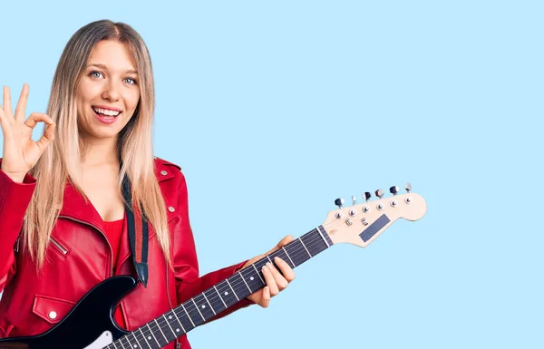 Jovem Bela Mulher Loira Tocando Guitarra Elétrica Fazendo Sinal Com — Fotografia de Stock