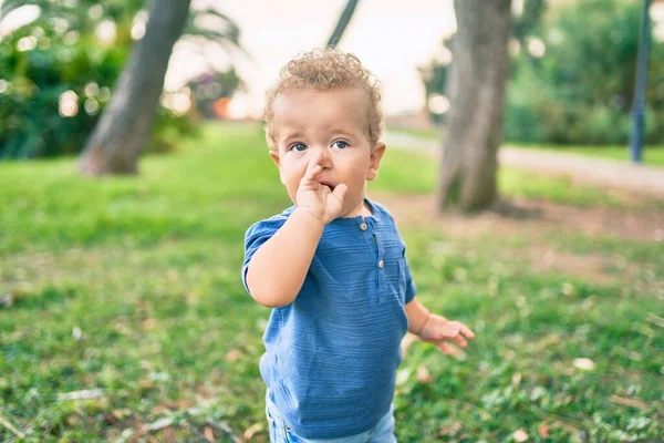 晴れた日に公園で歯痛が発生するので 悲しい小さな男の子が歯茎に指を触れて口に入れます 美しいブロンド髪男性幼児で痛みのために新しい赤ちゃん歯屋外 — ストック写真
