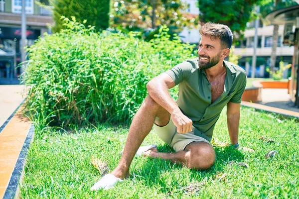 Joven Hombre Hispano Sonriendo Feliz Sentado Hierba Parque —  Fotos de Stock