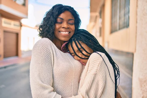 美しいアフリカ系アメリカ人の母親と娘の笑顔と抱擁 顔を笑顔で立って街に立って — ストック写真