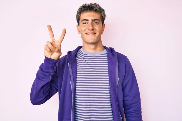 Joven Hombre Guapo Con Sudadera Púrpura Casual Sonriendo Con Cara —  Fotos de Stock