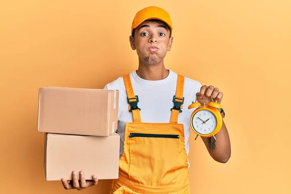Young Handsome African American Man Holding Delivery Box Alarm Clock — Stock Photo, Image