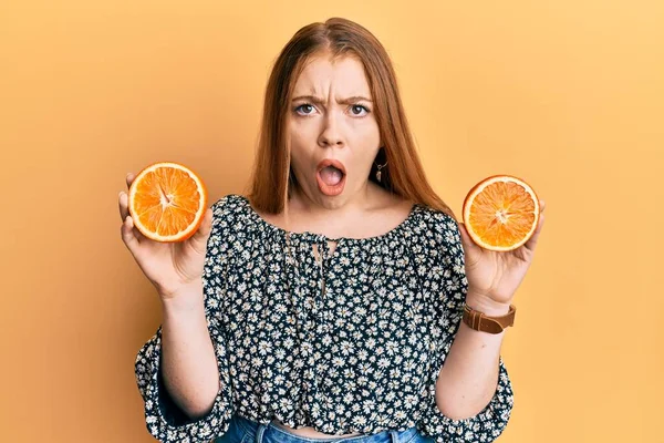 Mladý Krásný Ryšavý Žena Drží Čerstvé Pomerančové Plátky Šoku Tvář — Stock fotografie