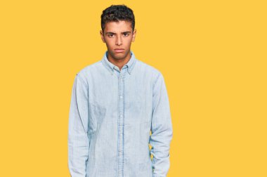 Genç, yakışıklı, Afro-Amerikan bir adam günlük kıyafetler giyiyor şüpheci ve gergin, sorun yüzünden üzgün. negatif kişi. 