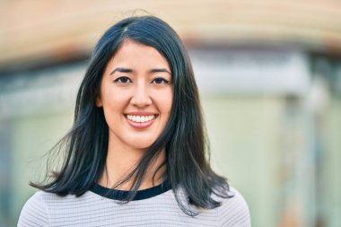 Genç İspanyol kadın gülümseyerek şehirde mutlu mesut yürüyor..