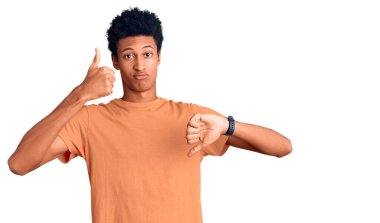 Genç Afro-Amerikan adam günlük kıyafetler giyip baş parmak kaldırıyor, anlaşmazlık ve anlaşma ifadesi takınıyor. çılgın çatışma 