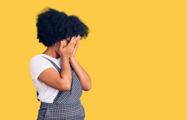 Genç Afro-Amerikalı kız, günlük kıyafetler giyip ağlarken suratını ellerle kapatıyor. depresyon kavramı. 