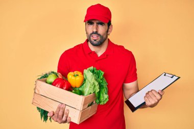 Yakışıklı, sakallı, üniformalı, teslimatçı, hiçbir şeyden haberi olmayan, kafası karışık bir adam. şüphe kavramı. 