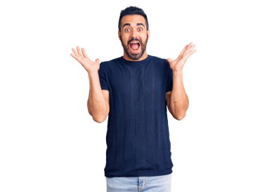 Gündelik kıyafetler giyen genç İspanyol adam zaferi mutlu bir gülümsemeyle ve kazanan yüz ifadesiyle kutluyor. 