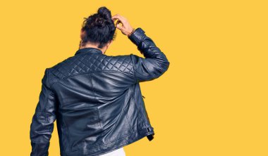 Gündelik deri ceket giyen genç bir Arap, elleri kafasında şüpheyi geriye doğru düşünüyor. 