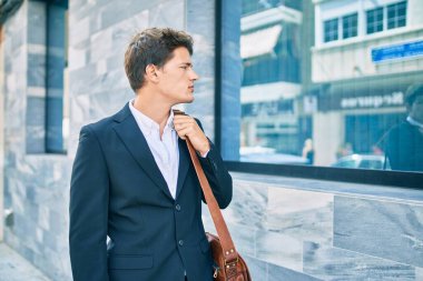 Kafkasyalı genç iş adamı, sakin bir ifadeyle şehirde yürüyor..