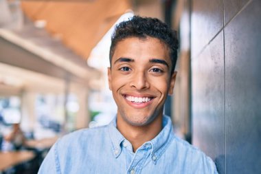 Genç Latin adam gülümseyerek şehirde mutlu mesut yürüyor..