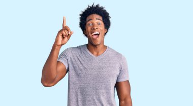 Afro saçlı, sıradan giyinmiş, başarılı bir fikri işaret eden yakışıklı Afro-Amerikalı adam. Heyecanlı ve mutlu. Bir numara.. 