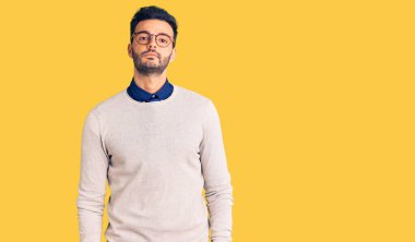 Zarif kıyafetler ve gözlük takan yakışıklı İspanyol adam yüzünde ciddi bir ifadeyle rahatlamış. Basit ve doğal bir şekilde kameraya bakıyorsun.. 