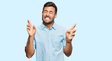 Yakışıklı İspanyol bir adam günlük kıyafetler giyip umut ve gözlerin kapalı gülümseyerek el sallıyor. Şans ve batıl inançlar. 