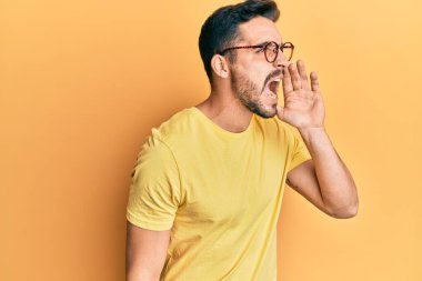 Günlük kıyafetler ve gözlük takan genç İspanyol adam el ele tutuşarak bağırıyor ve çığlık atıyordu. iletişim konsepti. 