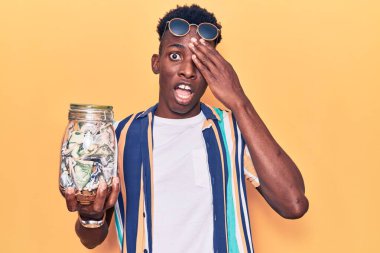 Genç Afro-Amerikan adam elinde kavanozla birikimlerini tutarken gergin ve hayal kırıklığına uğramış, şaşırmış ve sinirli bir yüz ifadesi vardı. 