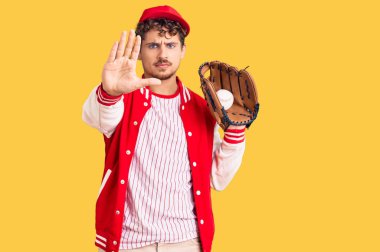Kıvırcık saçlı, beyzbol forması giyen, elinde Golve ve top tutan, ciddi ve kendinden emin bir ifadeyle dur işareti yapan yakışıklı bir genç. Savunma jesti. 