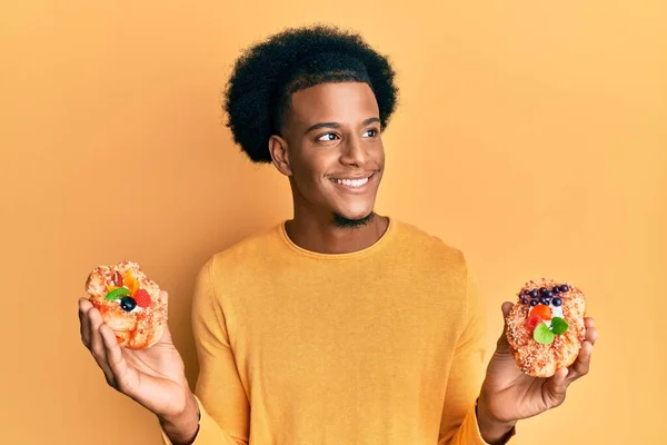 Hombre Afroamericano Con Cabello Afro Sosteniendo Dulces Pasteles Sonriendo Mirando — Foto de Stock