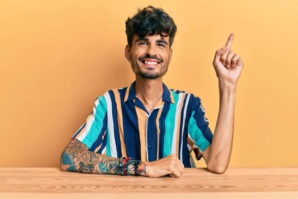 Jovem Hispânico Vestindo Roupas Casuais Sentado Mesa Sorrindo Feliz Apontando — Fotografia de Stock